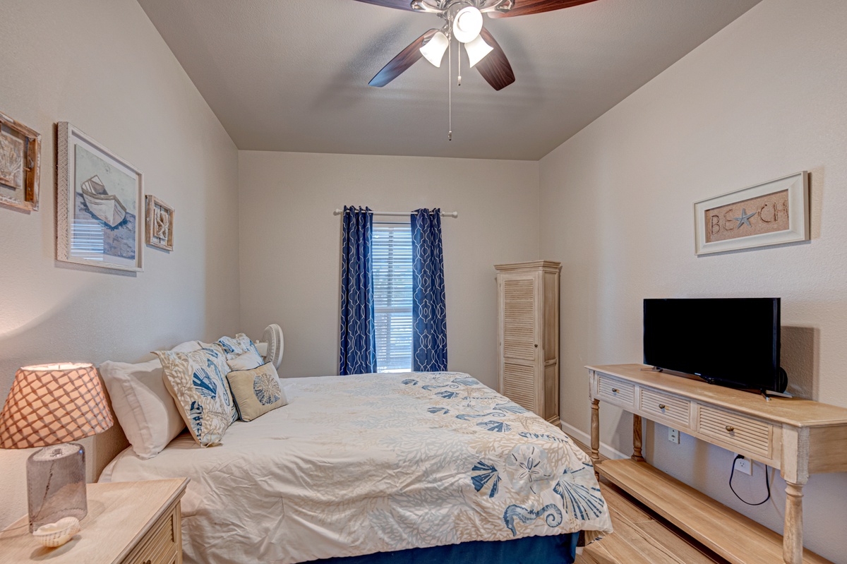 Drift off peacefully in your serene bedroom retreat, complete with coastal charm, ceiling fan comfort, and entertainment at your fingertips.