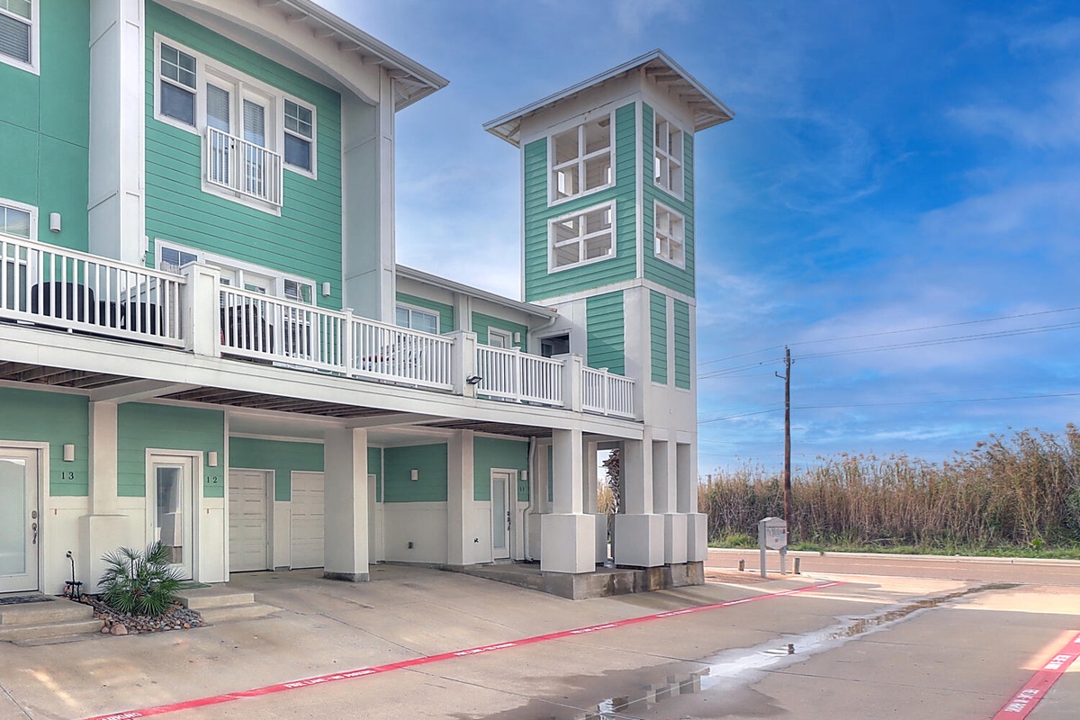 Modern coastal-style building with green siding and white trim offers comfortable vacation accommodations.