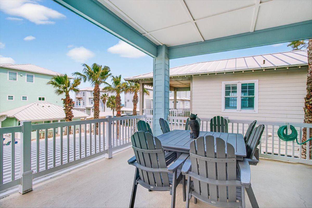Your covered balcony offers the perfect spot to enjoy morning coffee while taking in colorful beach houses and swaying palms.