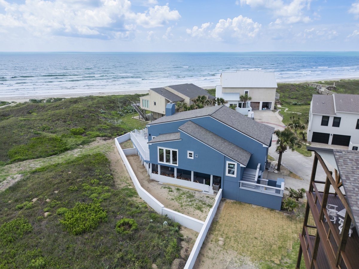 Stunning beachfront property nestled between ocean waves and coastal dunes, offering direct beach access in a pristine natural setting.