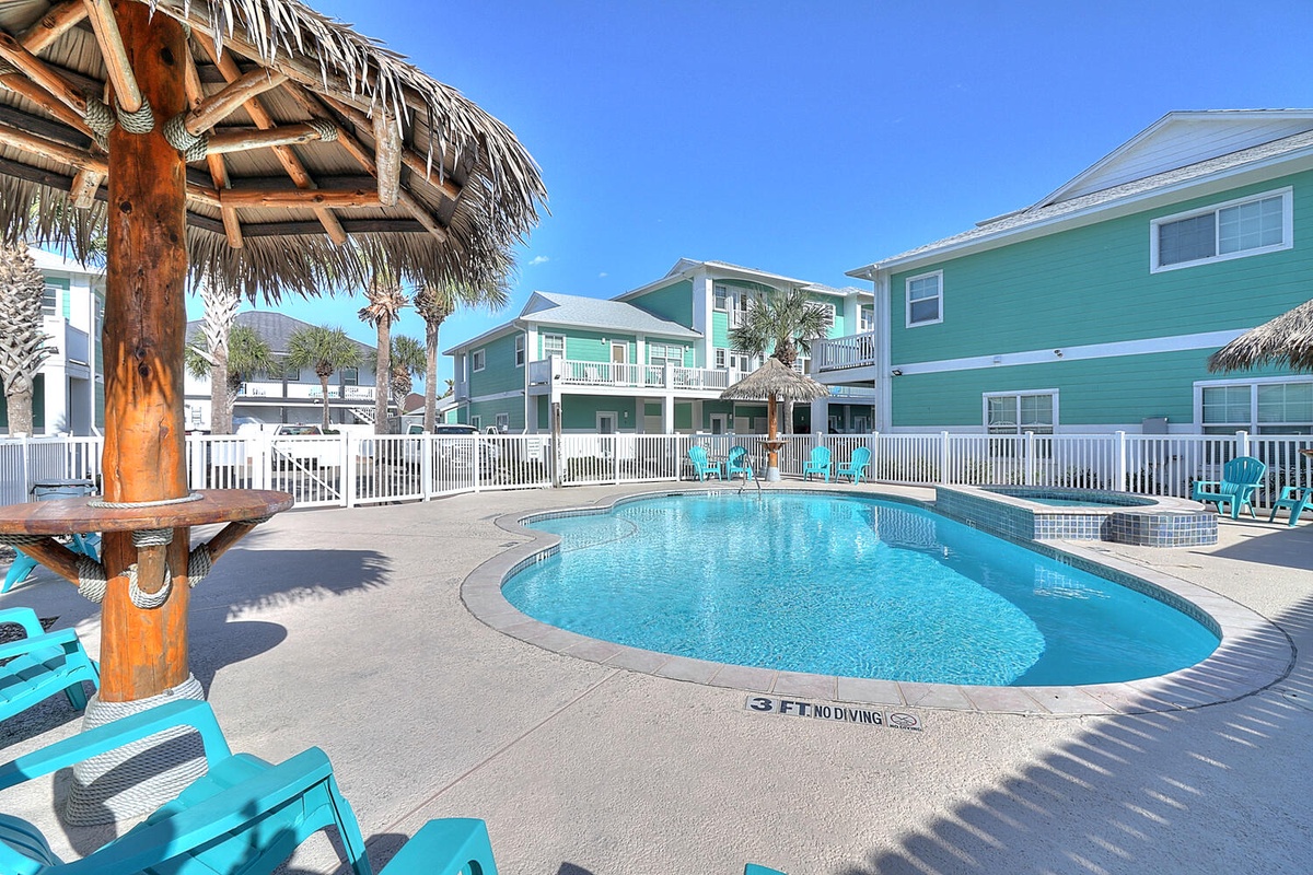 Sparkling pool awaits with tropical tiki shade and turquoise loungers, surrounded by cheerful beach house vibes.