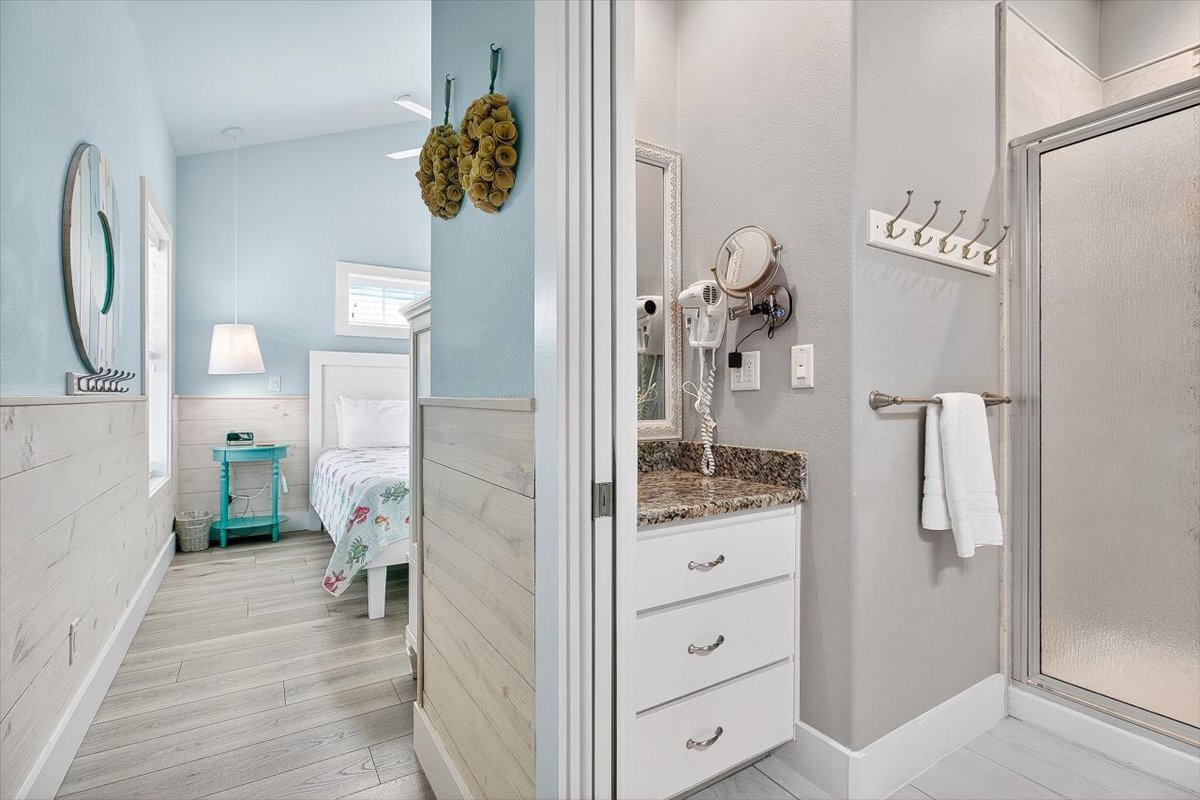 Your private bathroom features modern coastal styling with granite countertops and thoughtful amenities, connecting to a peaceful bedroom retreat.