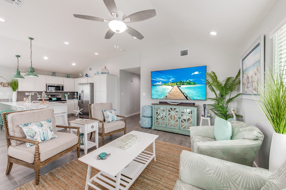 Unwind in your coastal-inspired living space with tropical decor, comfy seating, and an open kitchen perfect for vacation meals.