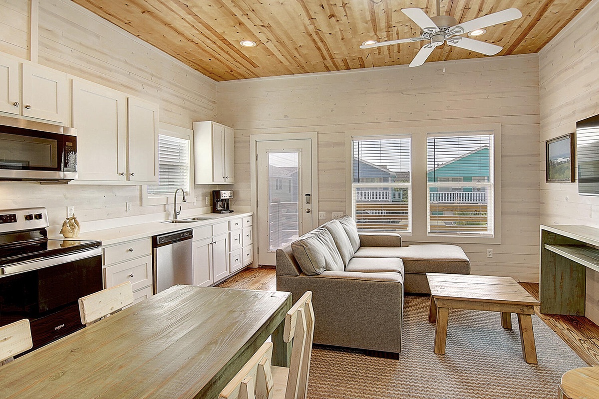 Relax in your bright open-concept space with warm wood ceilings, full kitchen, and cozy seating area.