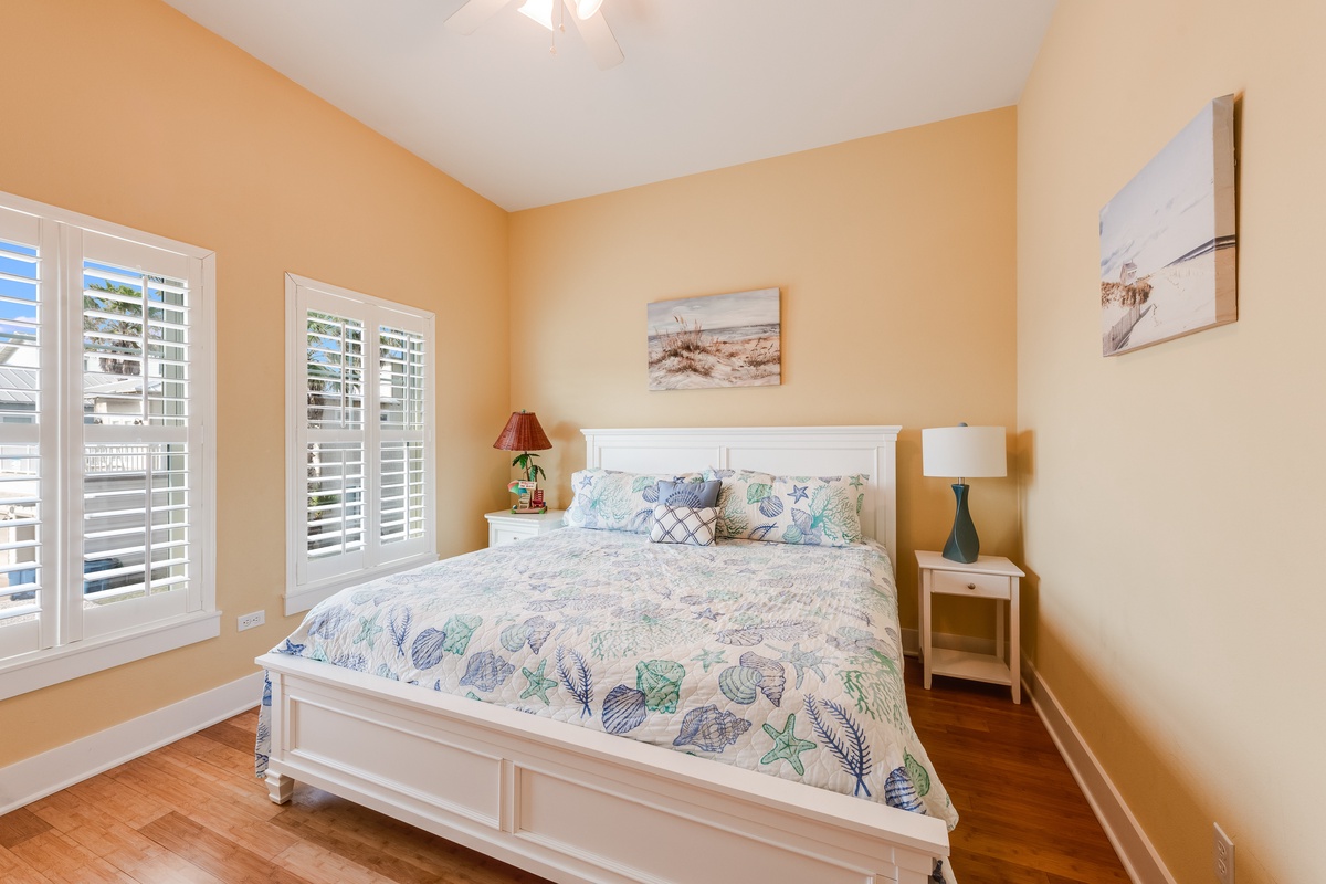 Drift off to sleep in this cozy coastal bedroom, where warm peach walls and ocean-themed bedding create your perfect seaside retreat.