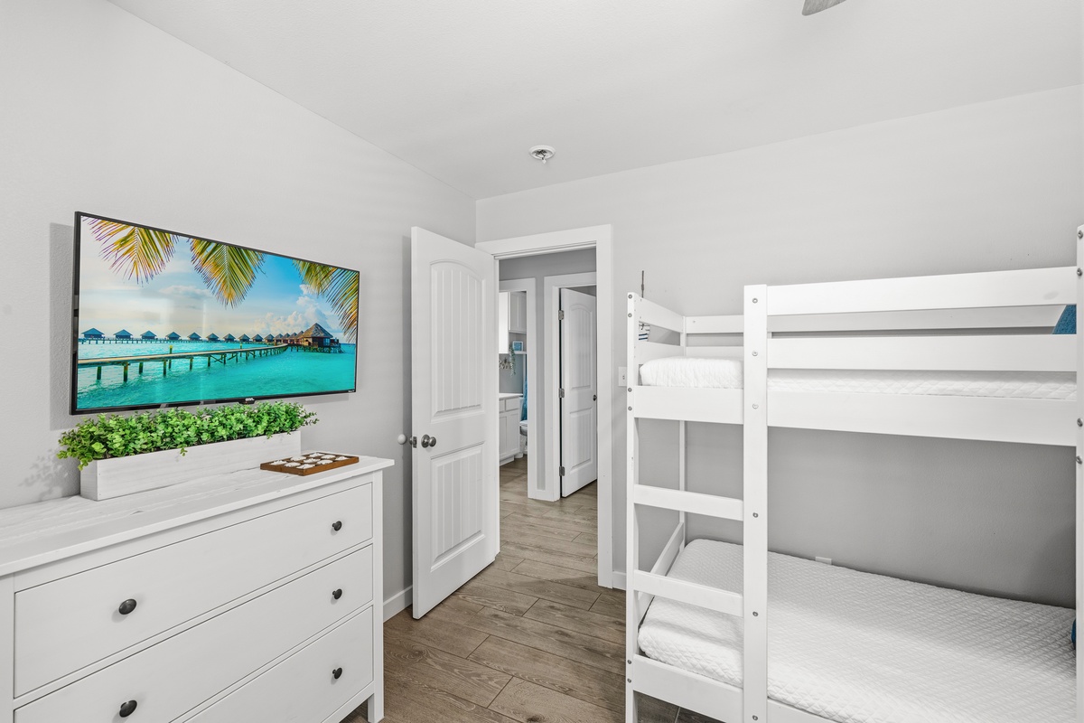This room features comfortable bunk beds and a wall-mounted TV for your entertainment, creating a cozy and functional space perfect for families or groups traveling together.