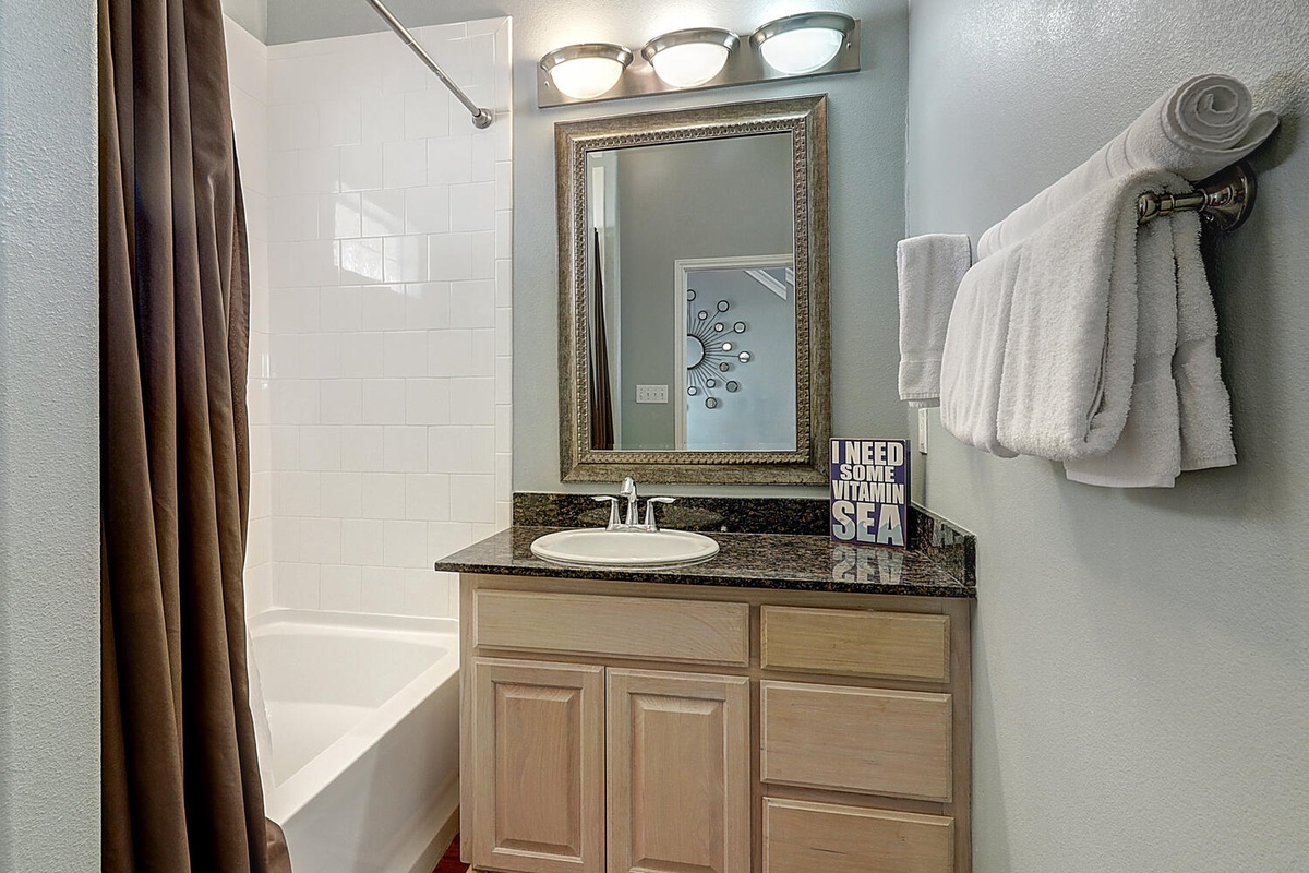 Step into your private bathroom featuring a granite vanity, framed mirror, and fluffy towels ready for your relaxing getaway.