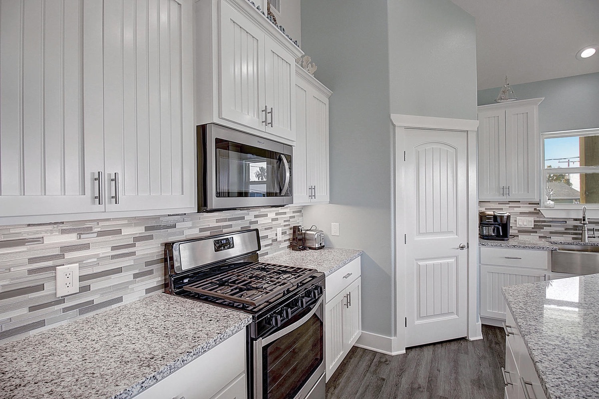 You'll love cooking in this bright, fully-equipped kitchen with granite counters, stainless appliances, and stylish backsplash.