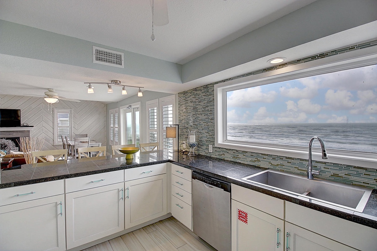 Cook with stunning ocean views right at your fingertips in this bright, modern kitchen featuring granite counters and stainless appliances.