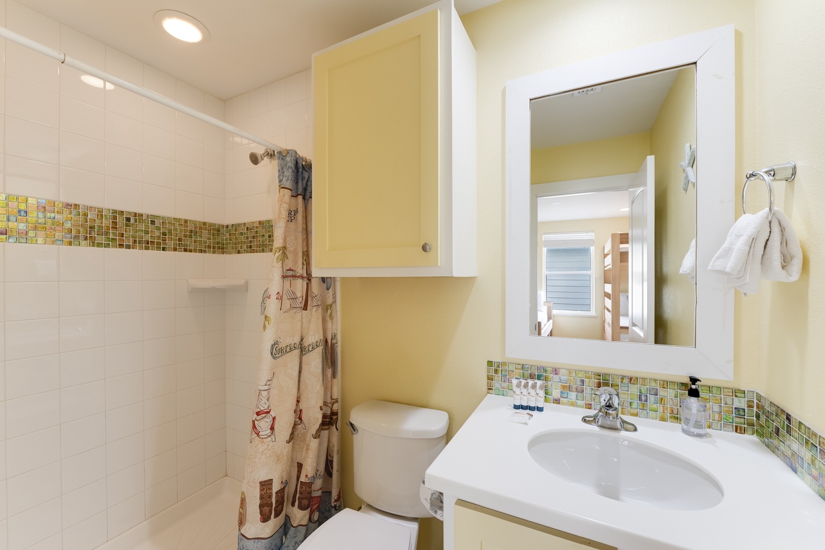 Your bright bathroom features cheerful tile work, a spacious shower, and thoughtful nautical touches that create a welcoming coastal retreat.