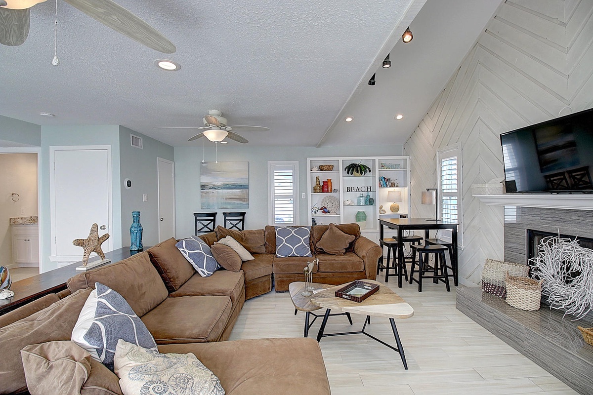 Sink into plush sectional seating in your coastal-inspired living space, featuring vaulted ceilings and beach decor.