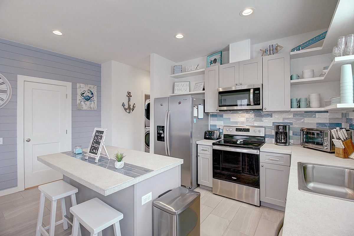 Your coastal-inspired kitchen welcomes you with bright white cabinets, modern appliances, and charming beach decor that makes cooking feel like a seaside escape.