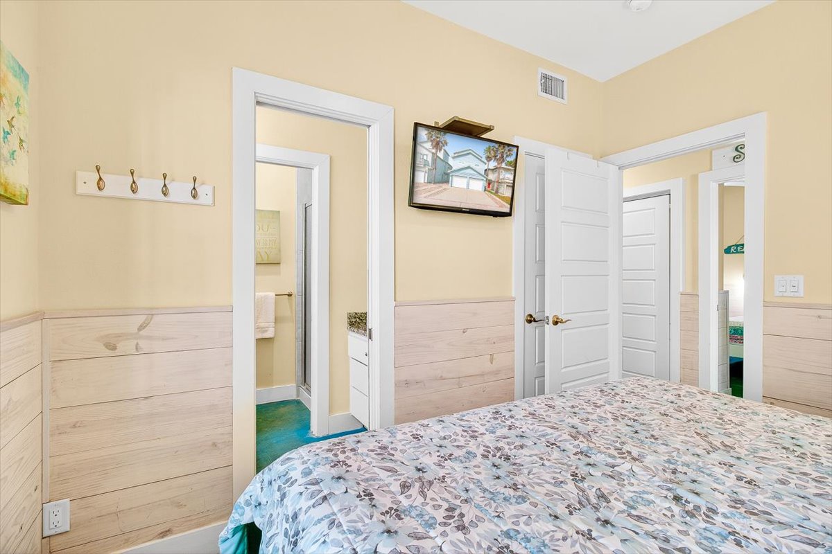 Rest comfortably in your coastal-themed bedroom featuring charming wood paneling, convenient hooks for your belongings, and entertainment at your fingertips.
