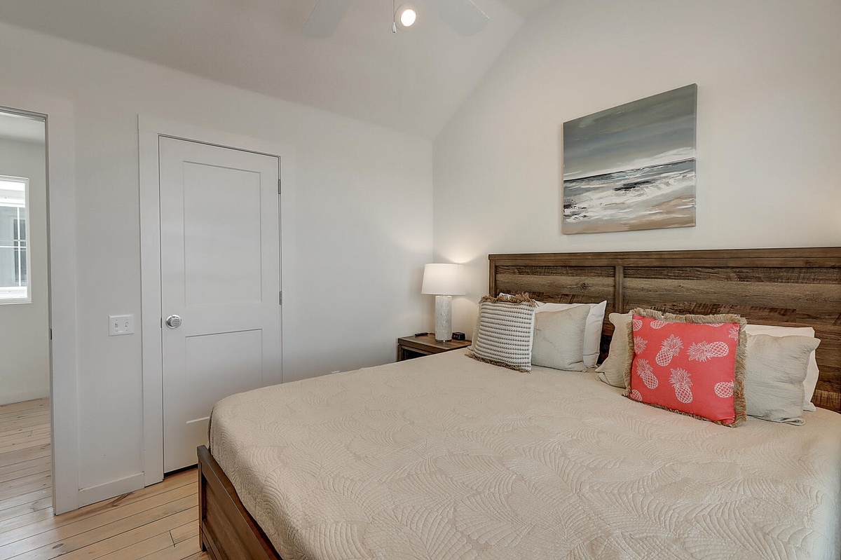 Drift off to peaceful sleep in your cozy bedroom, featuring a rustic wood headboard, soft linens, and coastal artwork above your bed.