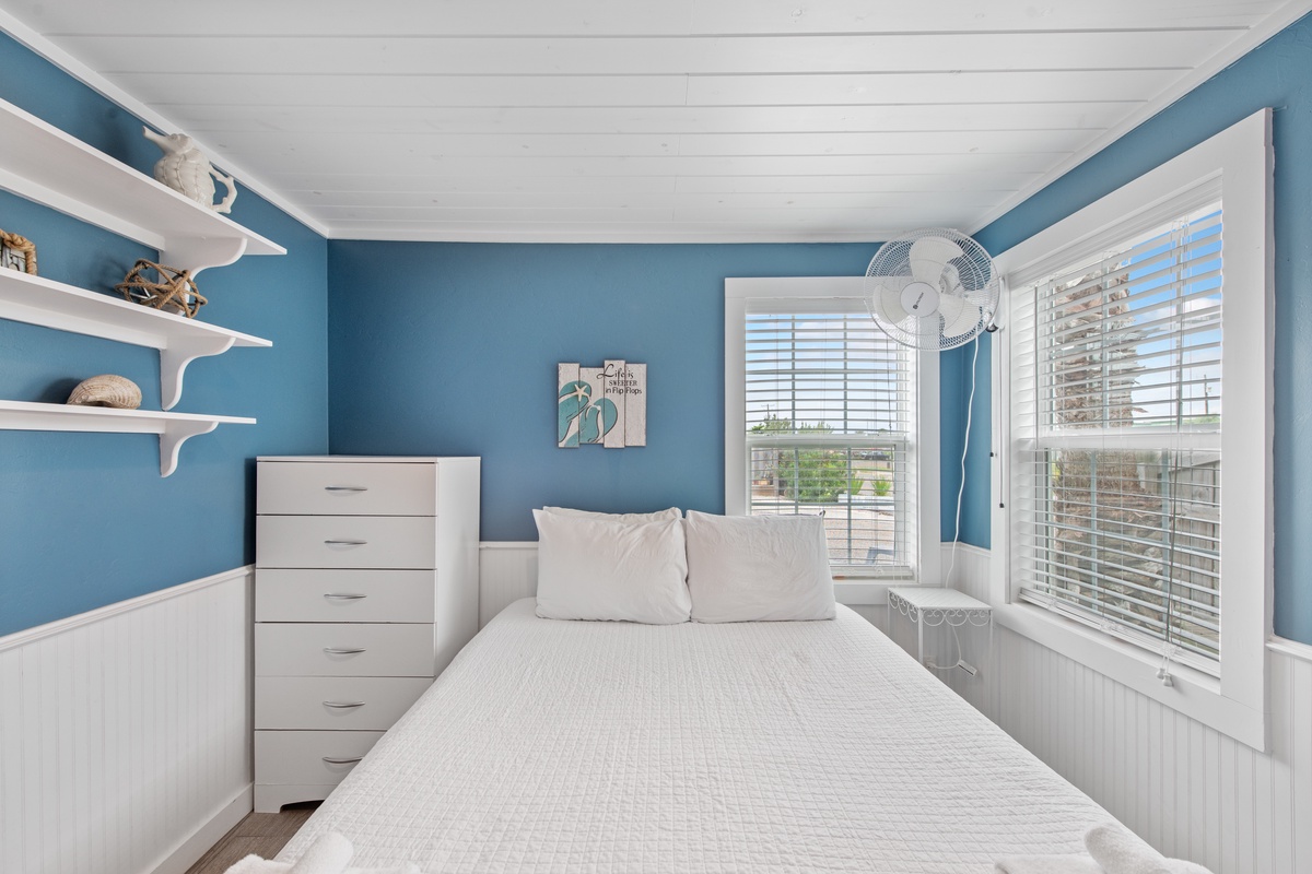 Drift off to sleep in your peaceful coastal bedroom, where sea-blue walls and white linens create the perfect seaside retreat.