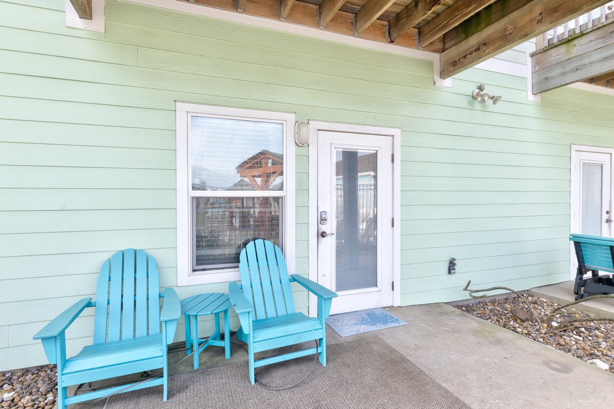 Relax on your private covered patio with turquoise Adirondack chairs, perfect for morning coffee or evening conversations.
