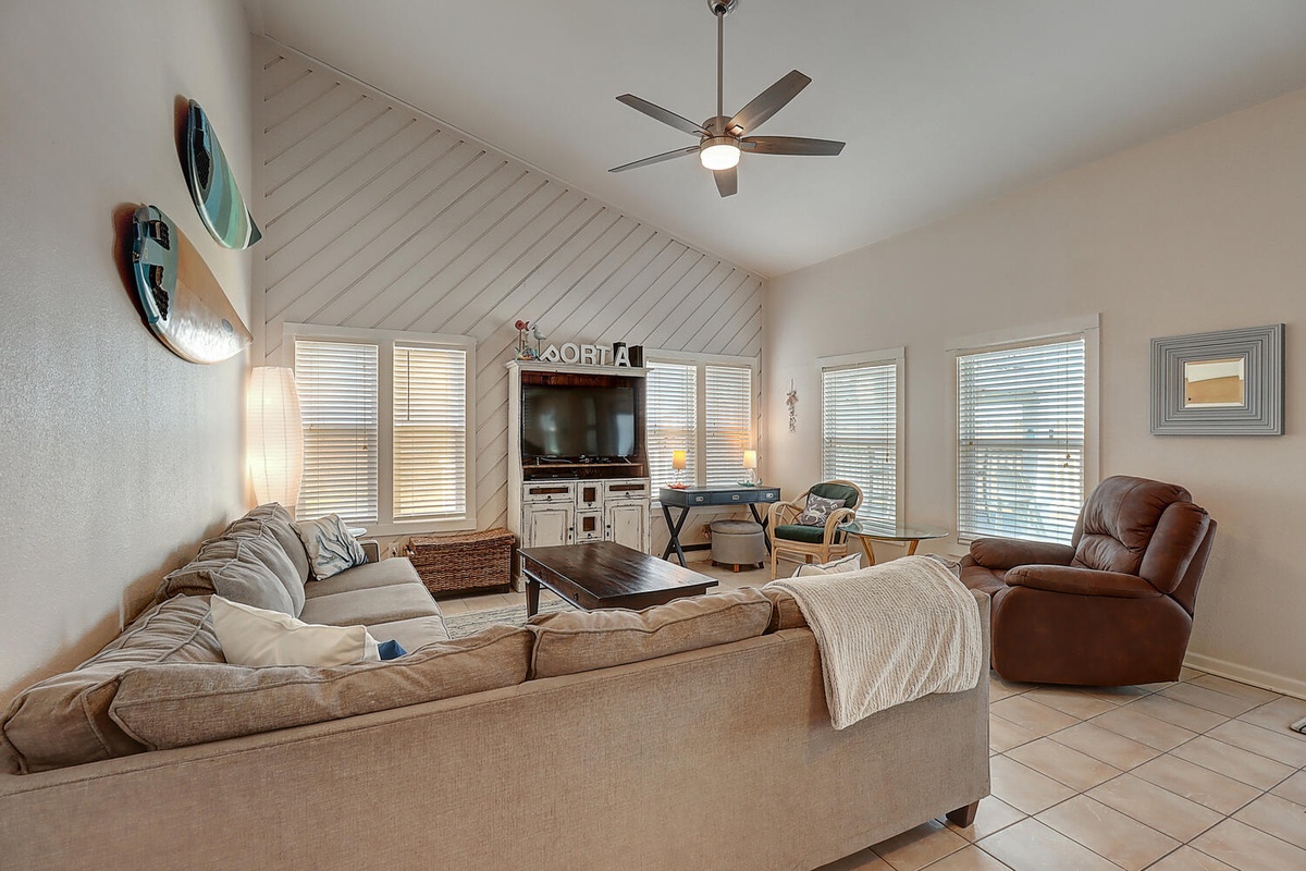 Unwind in your spacious living room with plush seating, entertainment center, and coastal touches for the perfect beach getaway retreat.