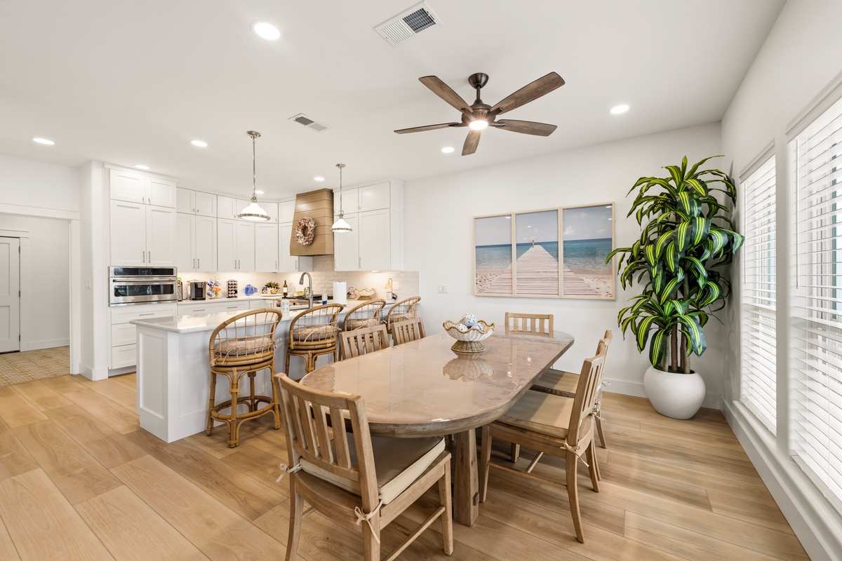 Gather around the spacious dining table in this bright, open kitchen where coastal charm meets modern comfort. Natural wood tones and soft lighting create the perfect setting for your memorable meals together.