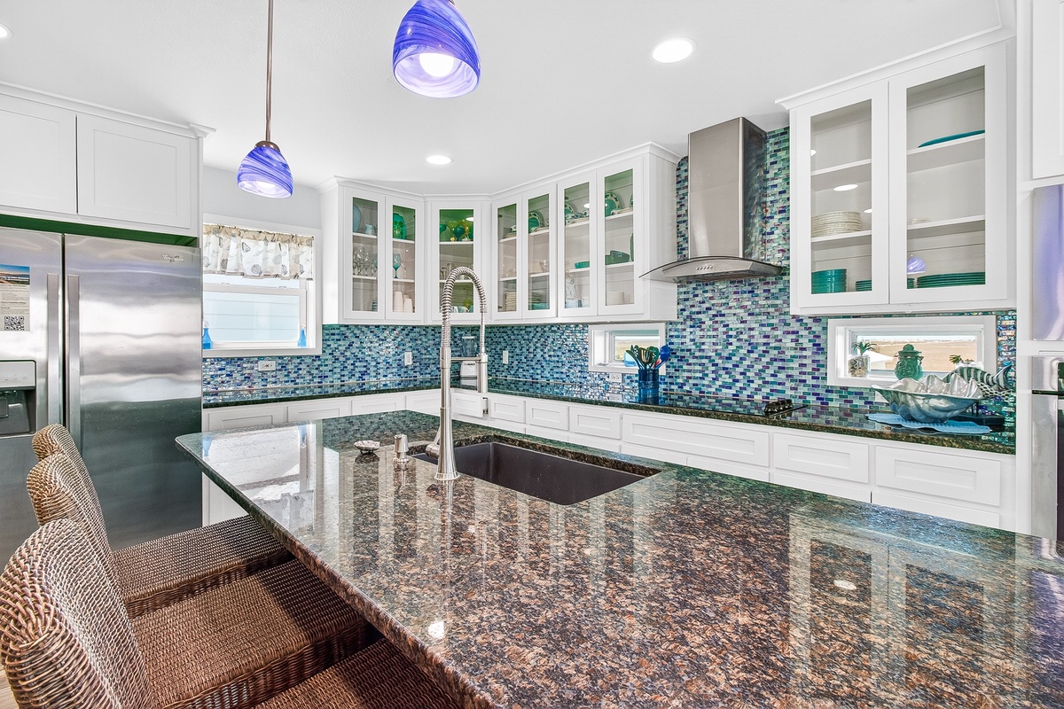 Your gourmet kitchen awaits with stunning blue mosaic backsplash, granite counters, and modern appliances for memorable meal preparation.