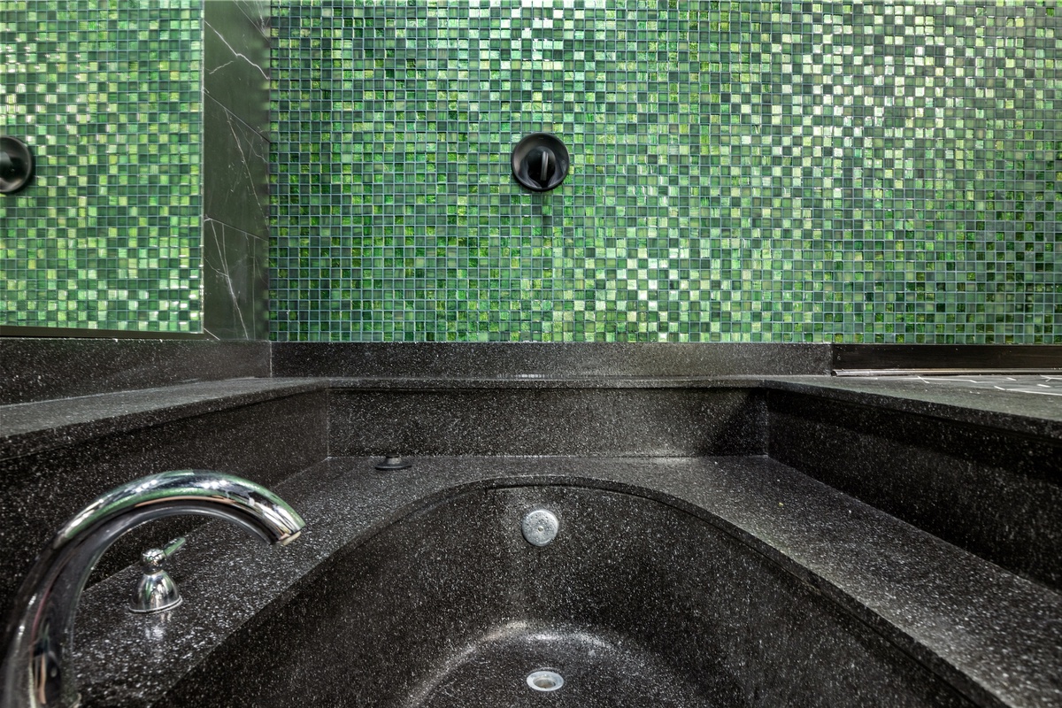 Unwind in your private spa-like bath surrounded by stunning emerald mosaic tiles that shimmer like jewels.