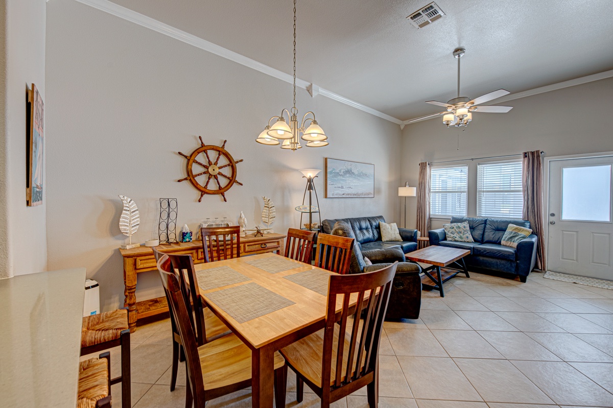 Gather around your warm dining table with nautical touches, then relax on plush blue sofas in this thoughtfully decorated open space.