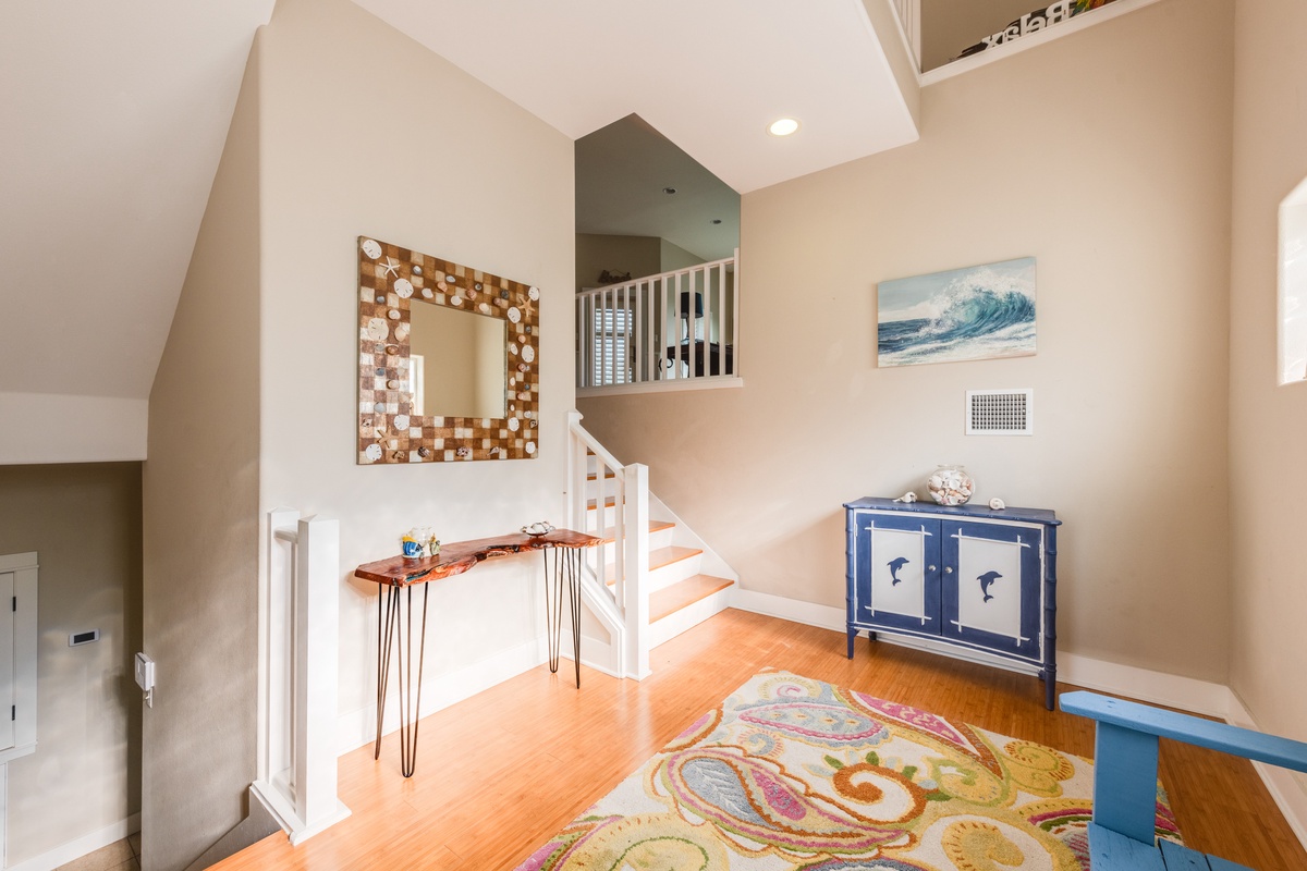 Step into your coastal-inspired entryway where warm wood floors and ocean art create an instant vacation vibe.