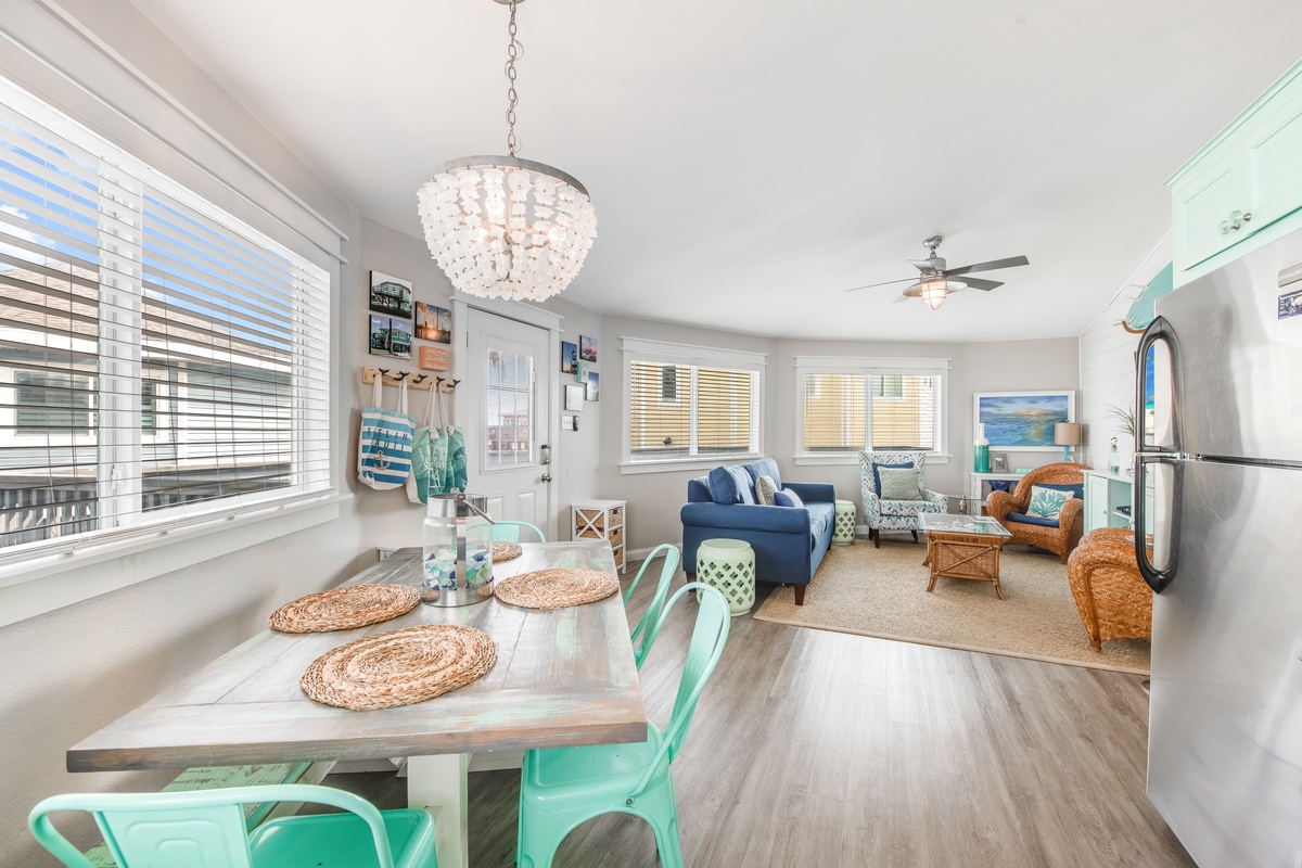 Step into your bright, coastal haven where natural light floods through elegant blinds, illuminating cheerful turquoise accents and comfortable seating.