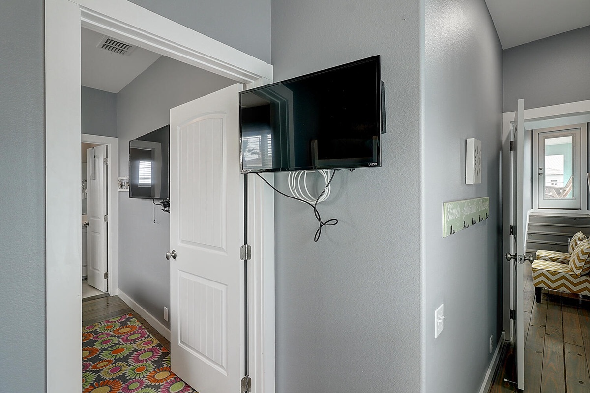 Your hallway connects all living spaces seamlessly, with a flat-screen TV for entertainment and convenient hooks for your belongings.