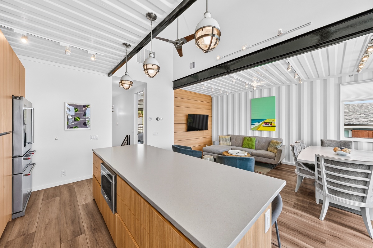 You'll love this open-concept space where sleek modern design meets industrial charm—cook at the spacious island, gather around the dining table, or unwind on the cozy sectional in your stylish retreat.