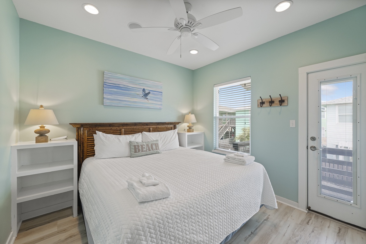 Slip into crisp white linens and let the coastal breeze drift through your private door to the deck—your serene retreat awaits with soft lighting and calming seaside hues.
