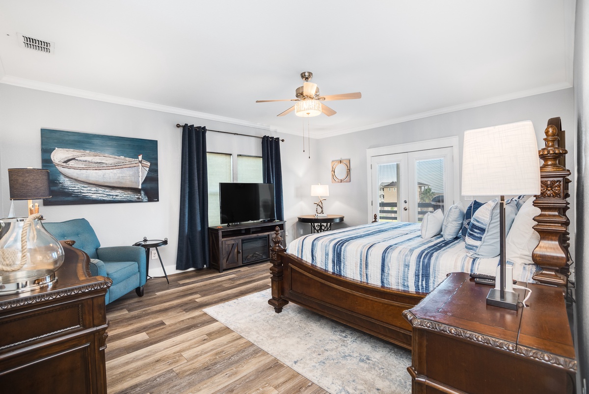 Sink into your coastal-themed bedroom with elegant four-poster bed, cozy reading chair, and nautical artwork creating a serene retreat.