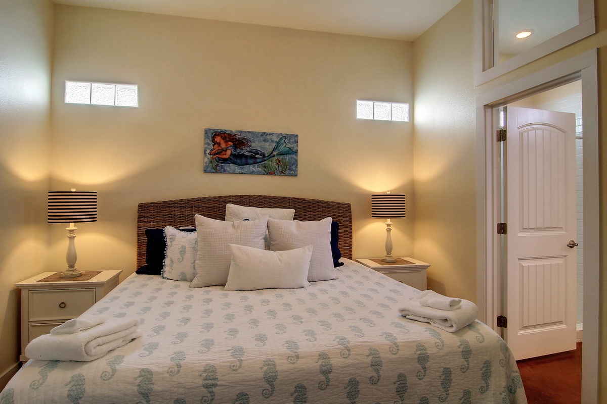 Drift into peaceful sleep in your coastal-themed bedroom with comfortable bedding and warm ambient lighting.