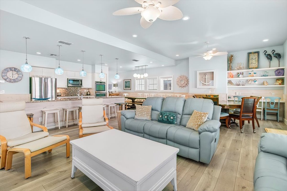 Relax in your spacious open-concept living area where coastal charm meets modern comfort, complete with a fully equipped kitchen and dining space.