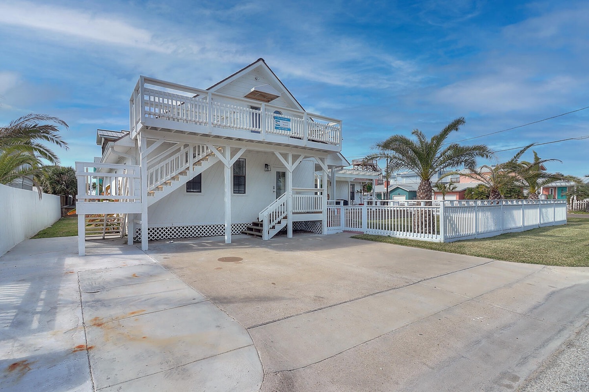 Charming coastal retreat with elevated deck and spacious driveway parking for beach gear and relaxation.