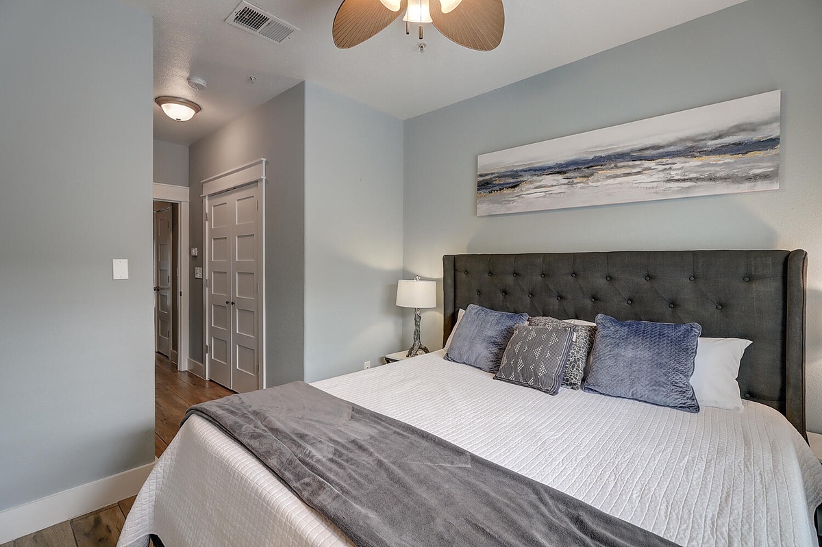 Sink into your plush tufted headboard surrounded by calming coastal artwork, soft lighting, and thoughtful touches for perfect relaxation.