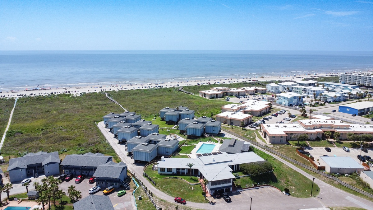 Beachfront vacation rental community featuring modern accommodations just steps from pristine sandy shores and calm ocean waters.
