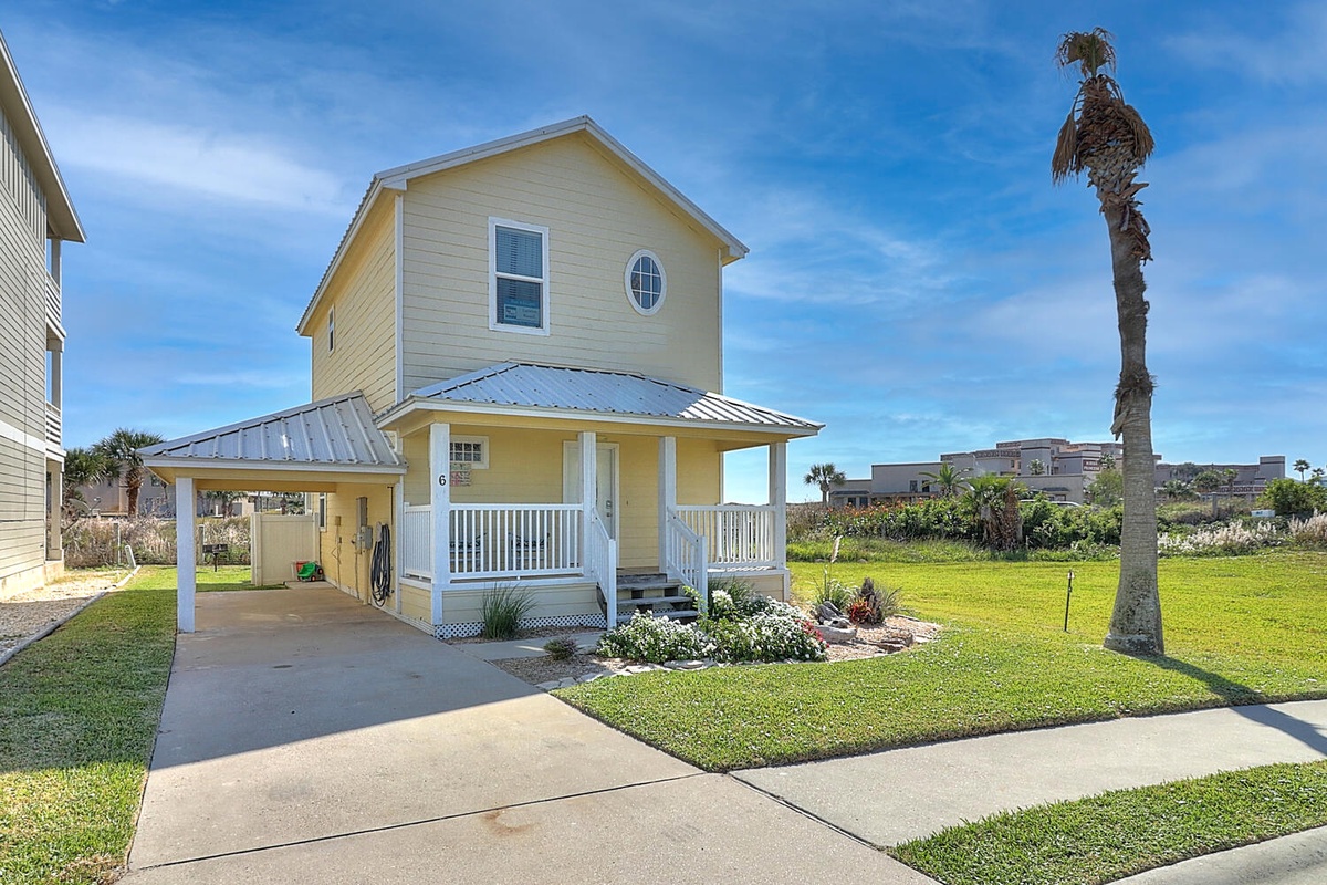 Charming coastal cottage with covered parking and tropical palm tree, perfectly positioned in a quiet residential neighborhood.