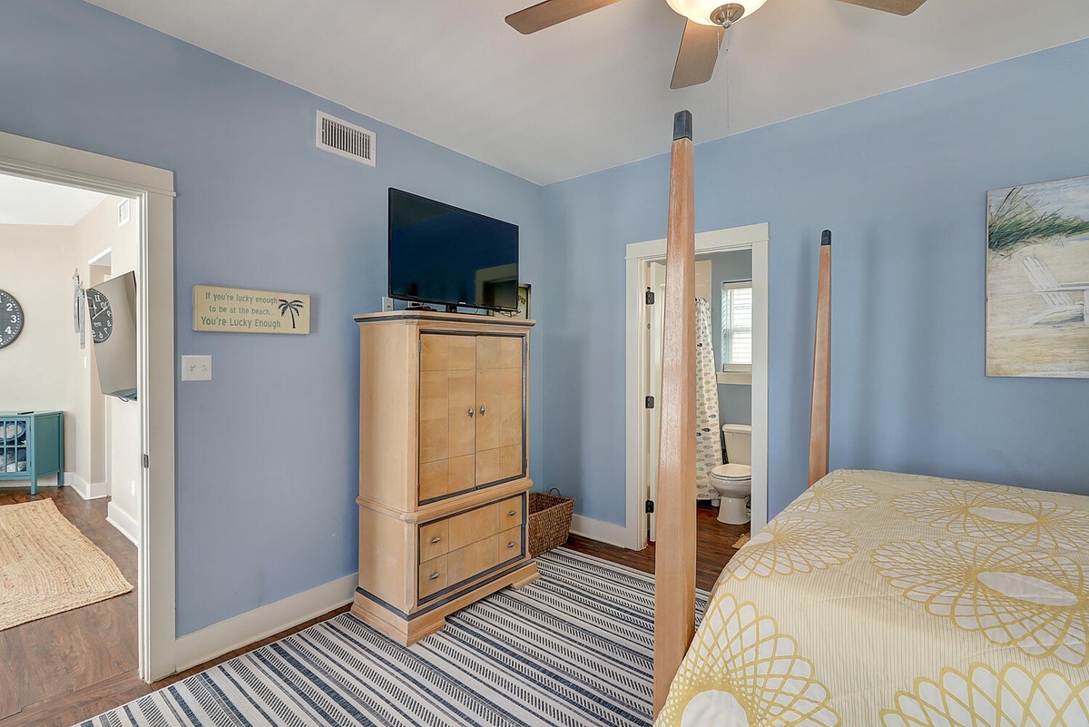 Drift off in your coastal-inspired bedroom, where calming blue walls and beach artwork create a peaceful retreat with modern comfort.
