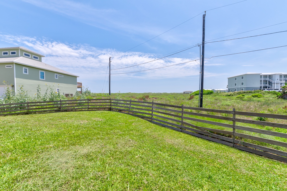 Coastal property featuring elevated deck structures and nearby rental homes in a quiet residential area.