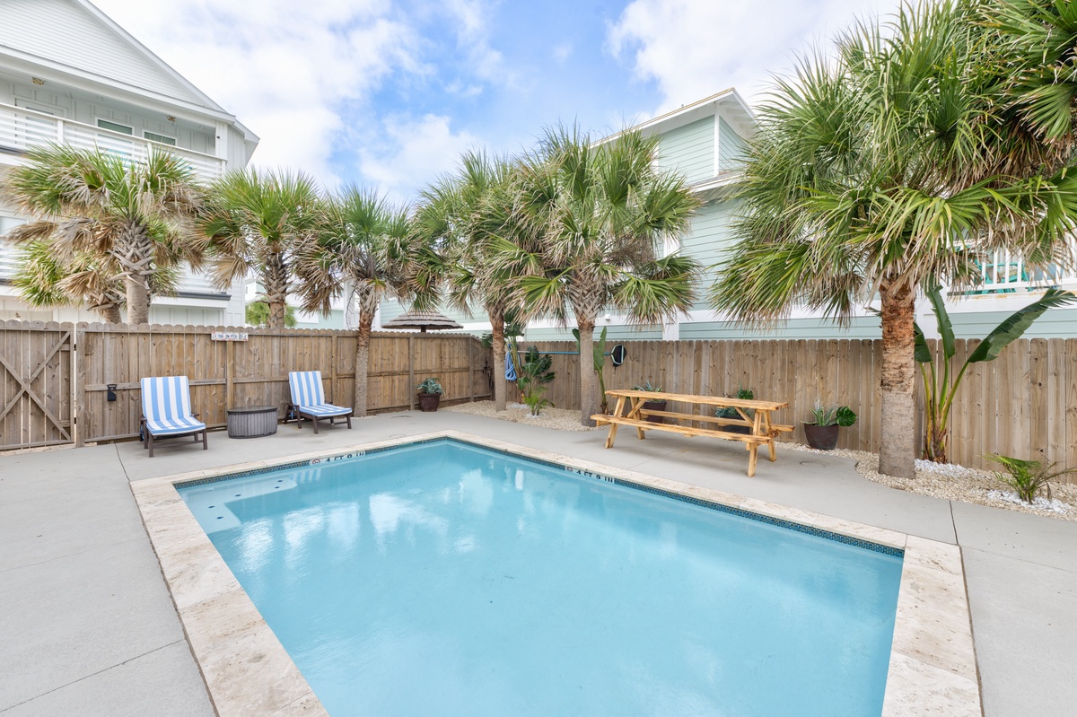 Dive into your private oasis! Sparkling pool surrounded by swaying palms, with comfy loungers for sunbathing and a picnic table for poolside dining.