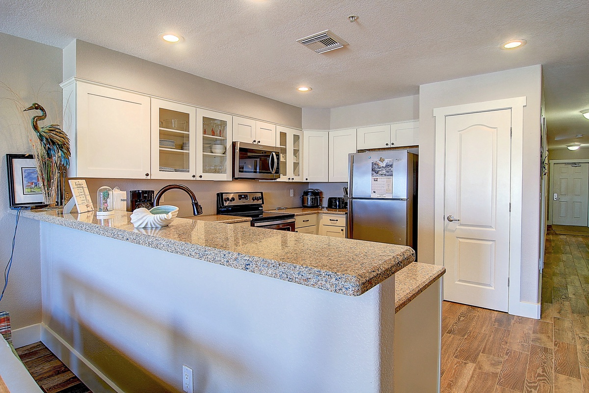 Your spacious kitchen features granite counters, stainless appliances, and ample cabinet space for preparing memorable vacation meals together.