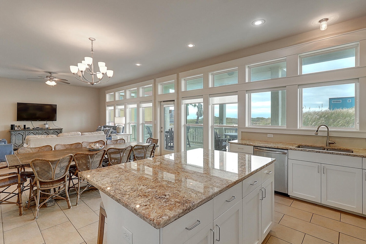 Cook with ocean breezes flowing through expansive windows as you prepare meals in this bright, granite-topped kitchen that opens to coastal views.