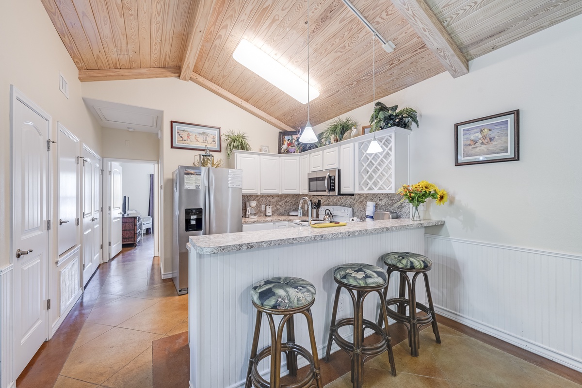 Whip up meals in your bright kitchen with granite counters, stainless appliances, and breakfast bar seating beneath stunning wooden cathedral ceilings.
