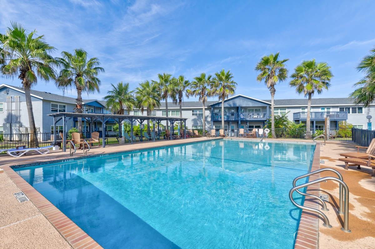 Crystal clear pool surrounded by swaying palms creates your perfect tropical escape. Plenty of lounge chairs and shaded seating await your relaxation.