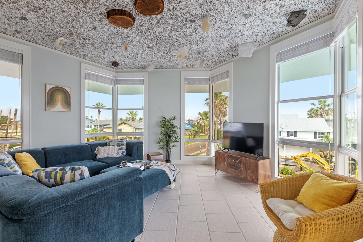 Sink into plush seating while soaking up stunning palm tree views through floor-to-ceiling windows in your bright, stylish living space.