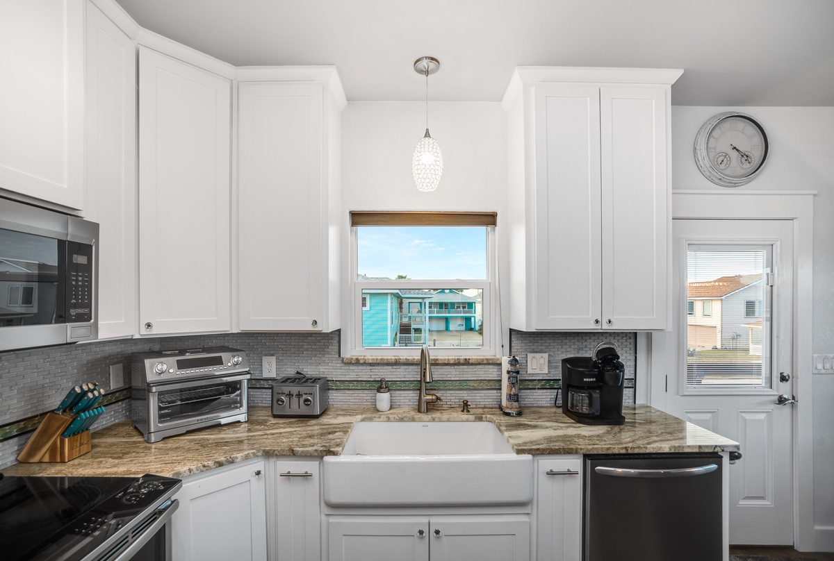 Your gourmet kitchen awaits with gleaming white cabinets, granite counters, and a farmhouse sink. Coffee maker ready for morning brews!