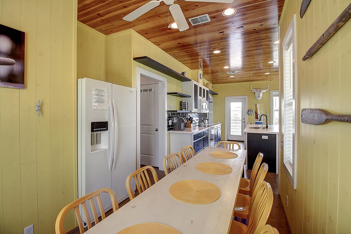 Gather around this spacious dining table where your group can share meals beneath beautiful wood beam ceilings in this fully-equipped kitchen.