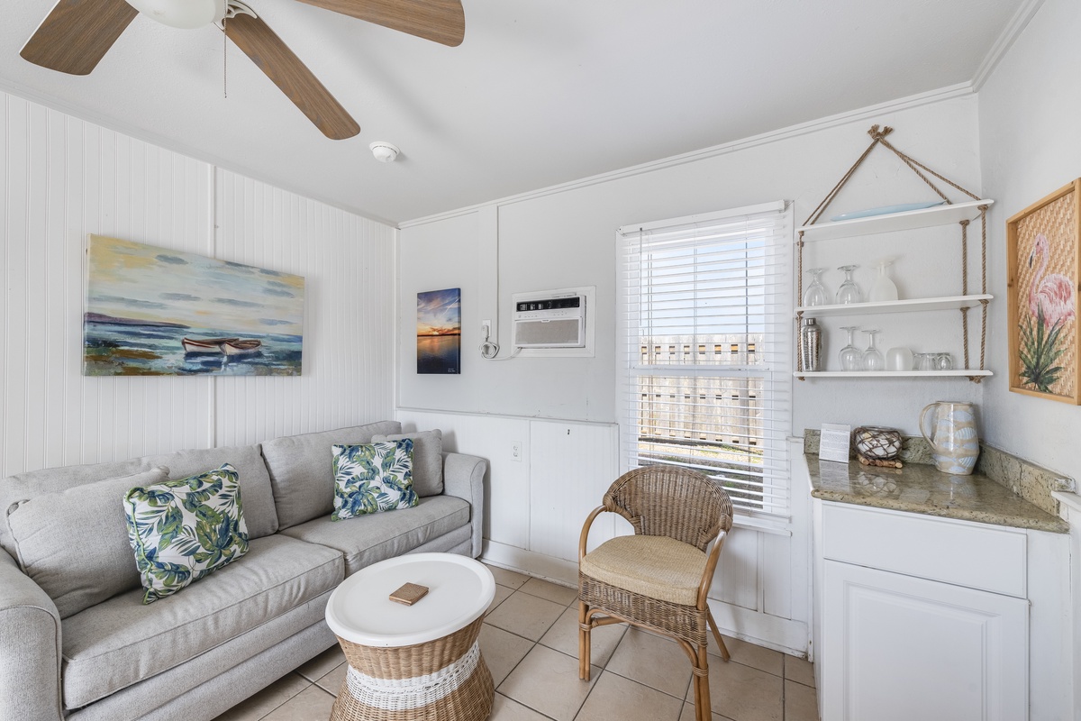 Relax in your coastal-inspired living space with tropical touches, custom shelving, and air conditioning for ultimate comfort.