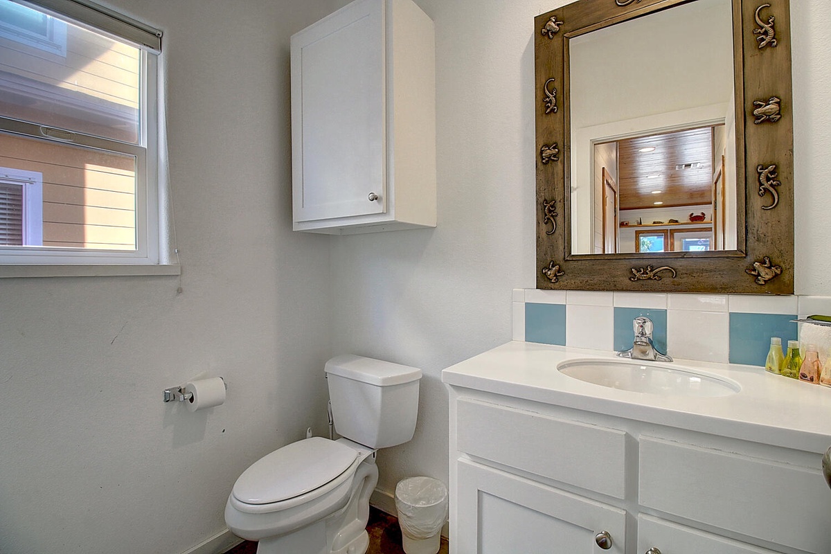 Your private bathroom features a charming rustic mirror and crisp white fixtures, creating a clean, comfortable space for your stay.