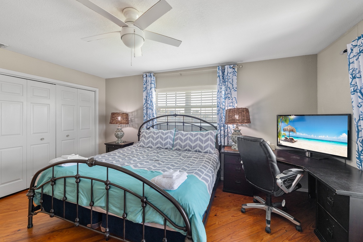 Settle into your coastal-inspired bedroom with a comfy bed, ceiling fan, and workspace—perfect for relaxing or catching up after a day of adventure.